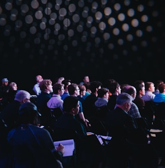 crowd of people sitting on chairs inside room