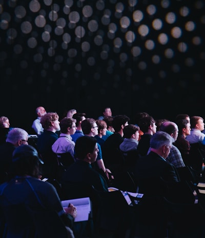 crowd of people sitting on chairs inside room