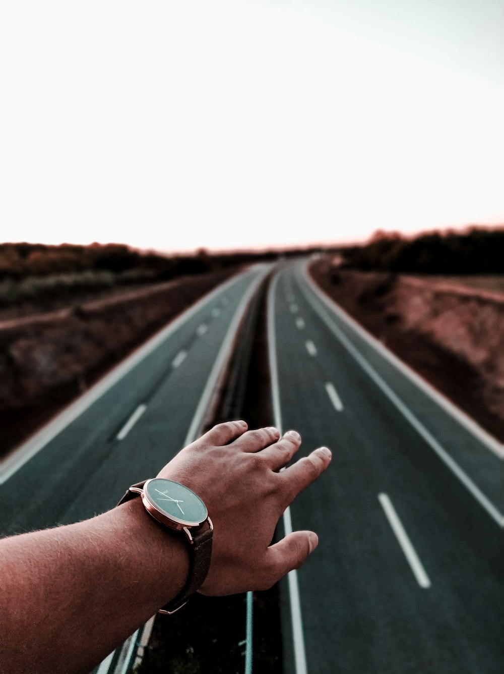 a person holding their hand out on a highway
