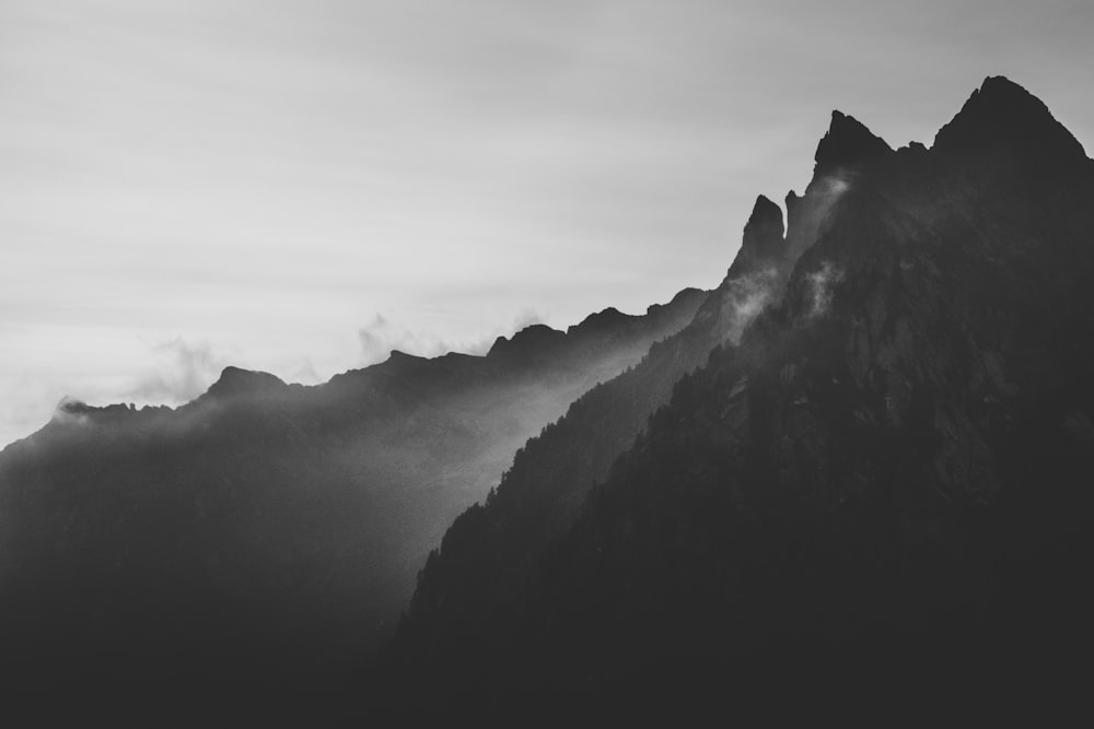 Fotografia della silhouette della montagna sotto la nebbia
