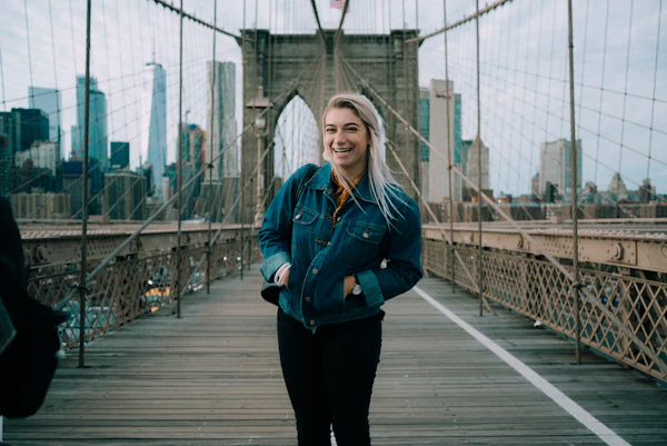 Viajera sonriendo en el puente de Brooklyn
