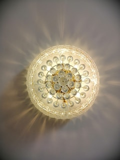 A sparkling contemporary crystal ceiling light casting warm, inviting patterns on a cozy living room ceiling.
