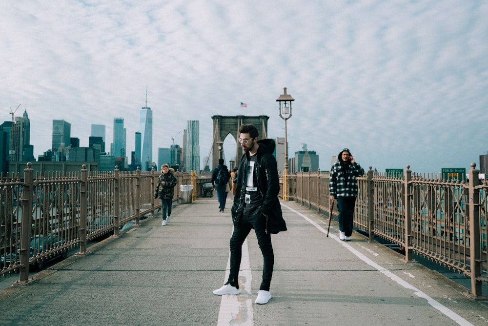 man standing on bridge