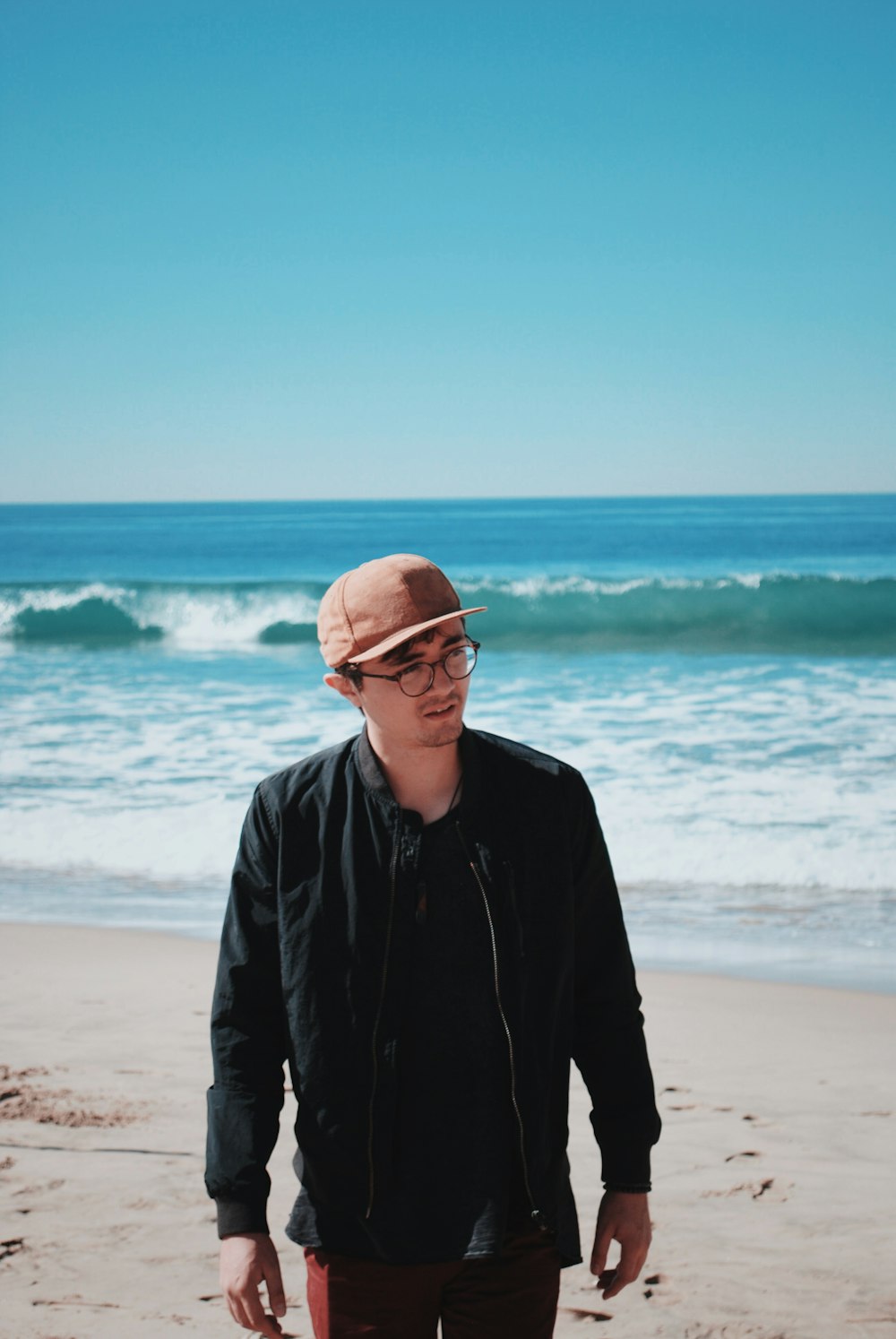 man standing near beach line