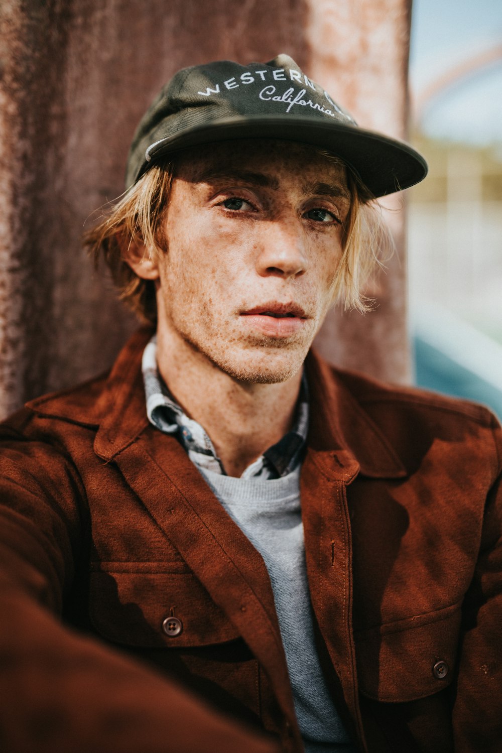 man wearing fitted cap and orange blazer