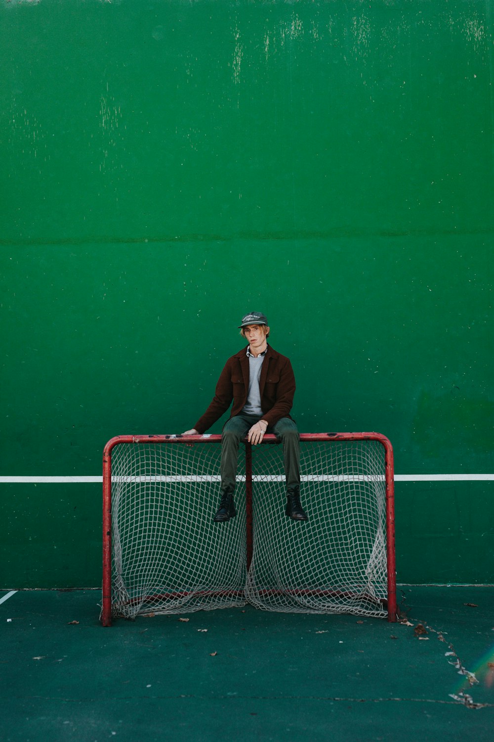 man sitting red net goal