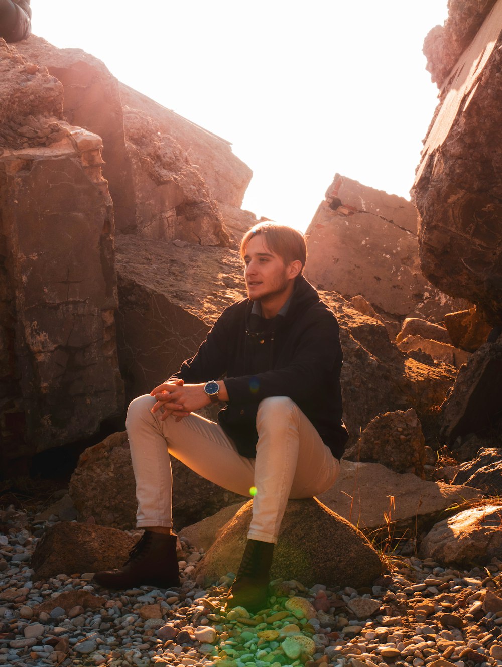 man sitting on brown stone