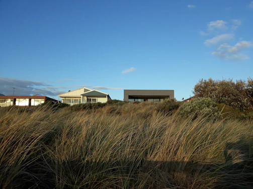 A serene beach view with a modern beach house in the foreground.