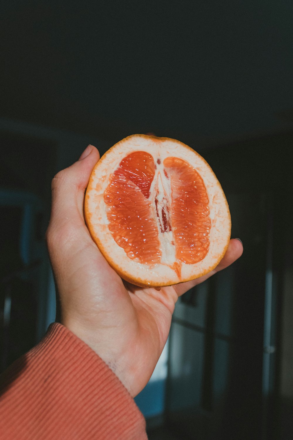 person holding sliced orange fruit