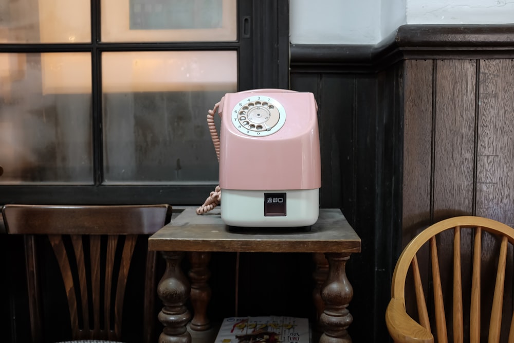 茶色のテーブルの上のピンクと白の電話