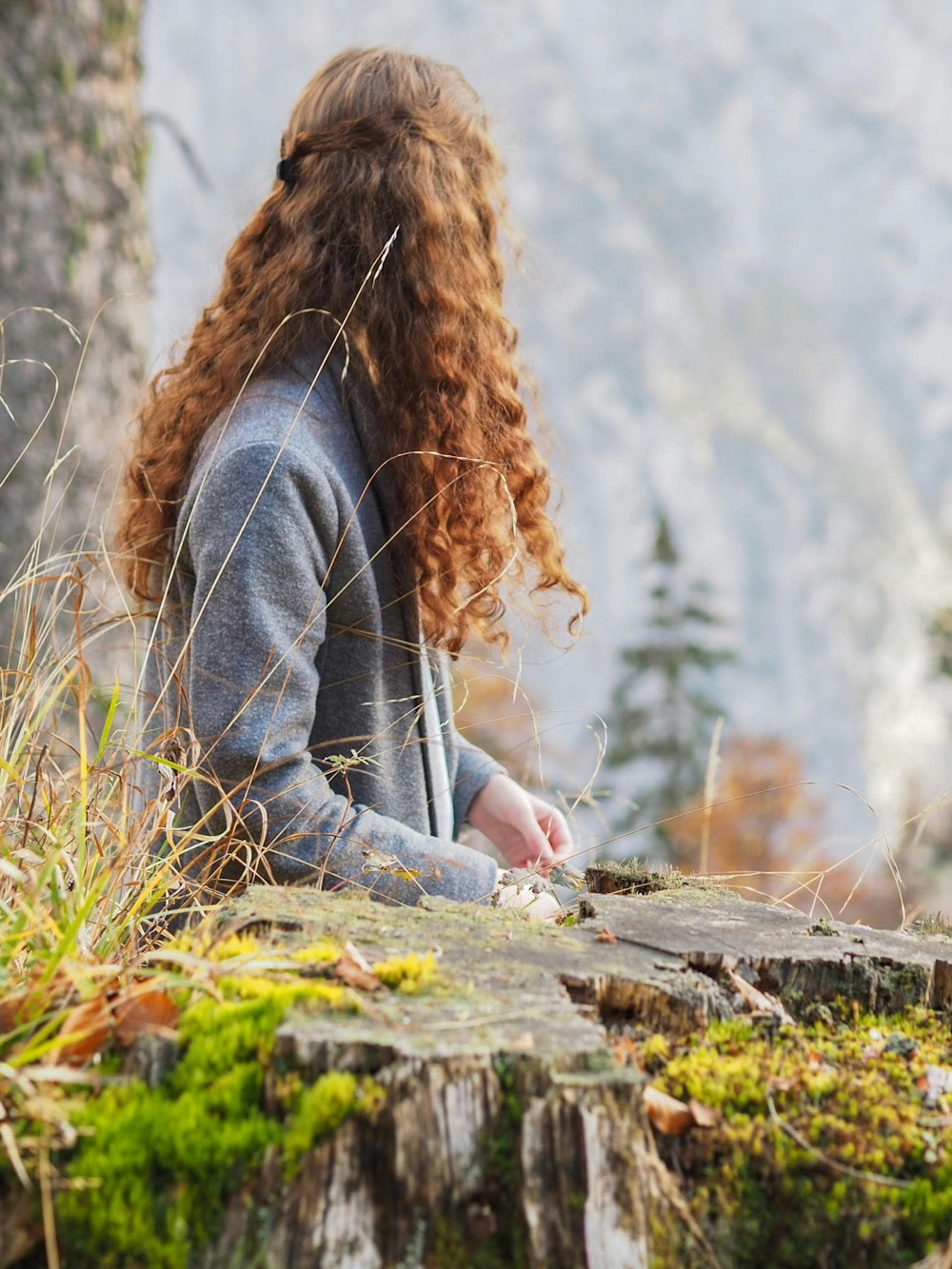 woman wearing sweatshirt standing in front of tree stamp