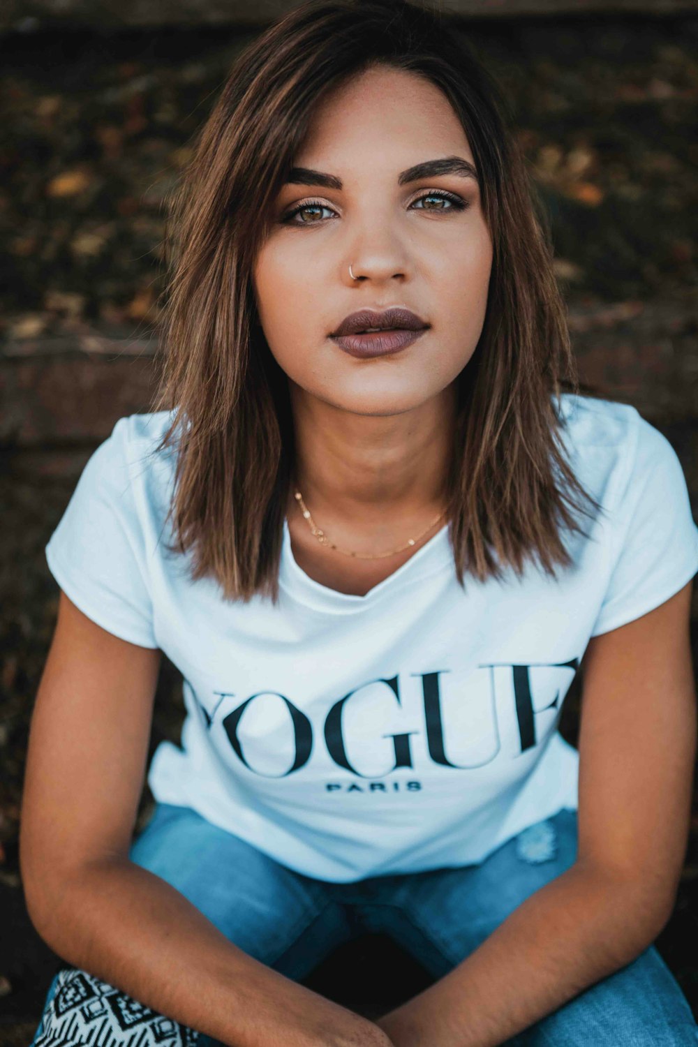 mulher na camiseta branca da Vogue e jeans azul