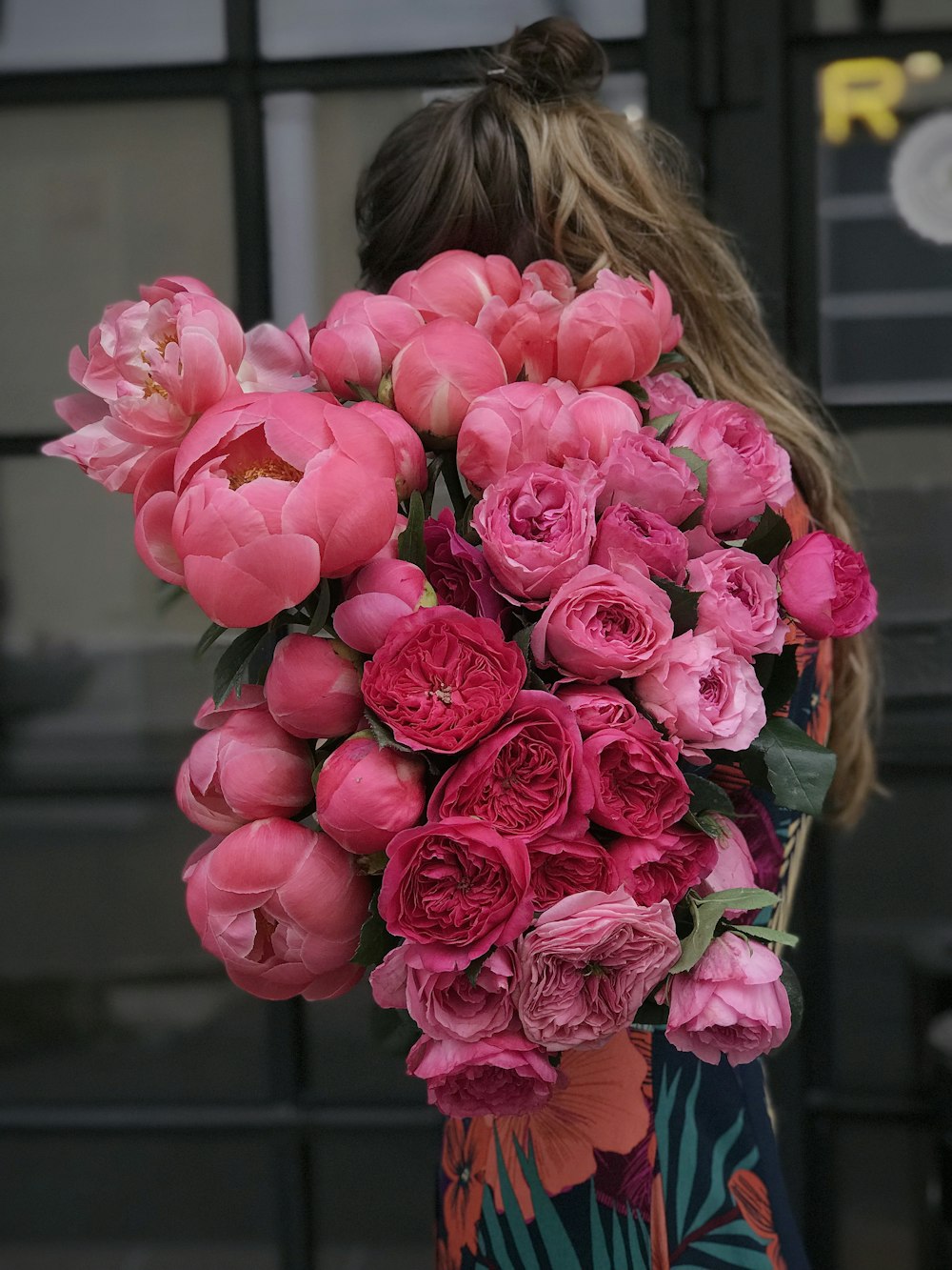 Femme tenant des fleurs roses