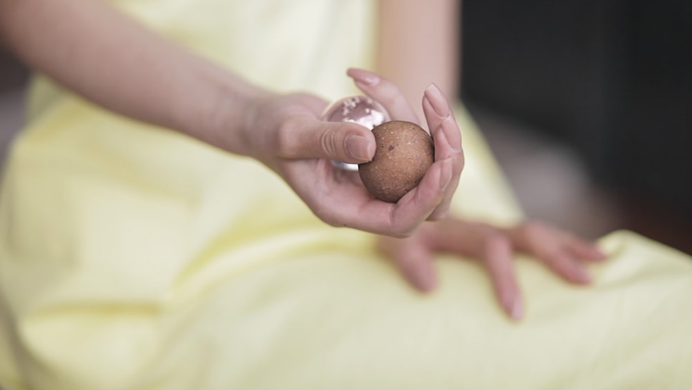 person holding two round tools