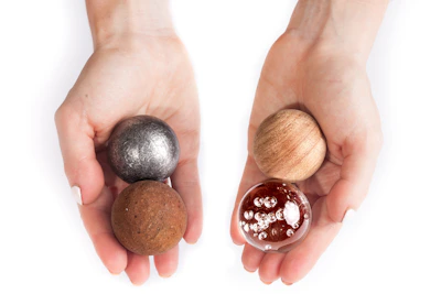 Hands of a child exploring a tactile sensory ball with vibrant colors.