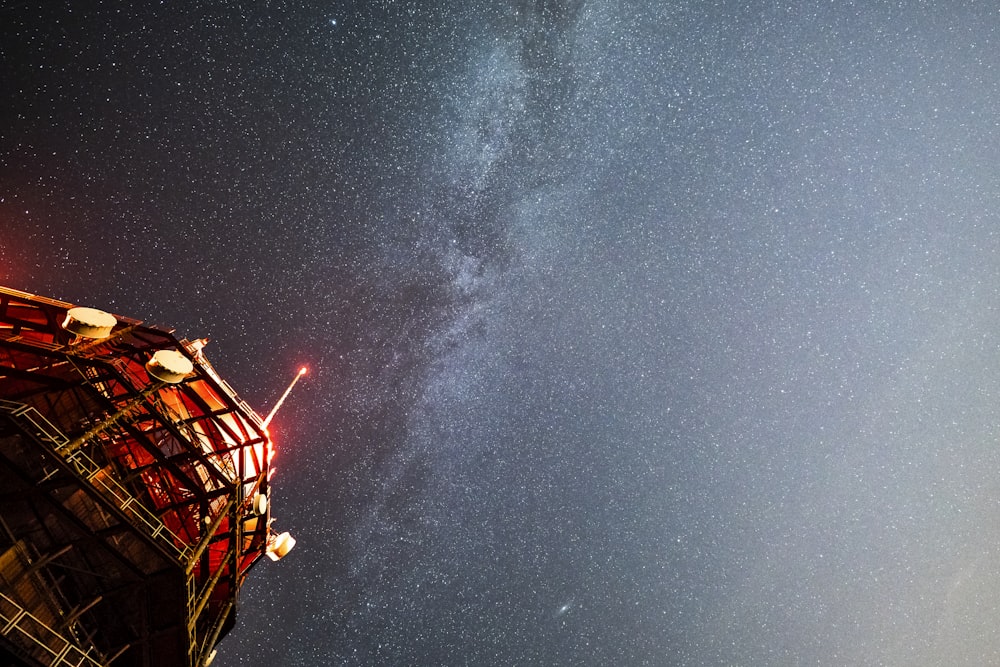 a tall tower with a light on top of it under a night sky