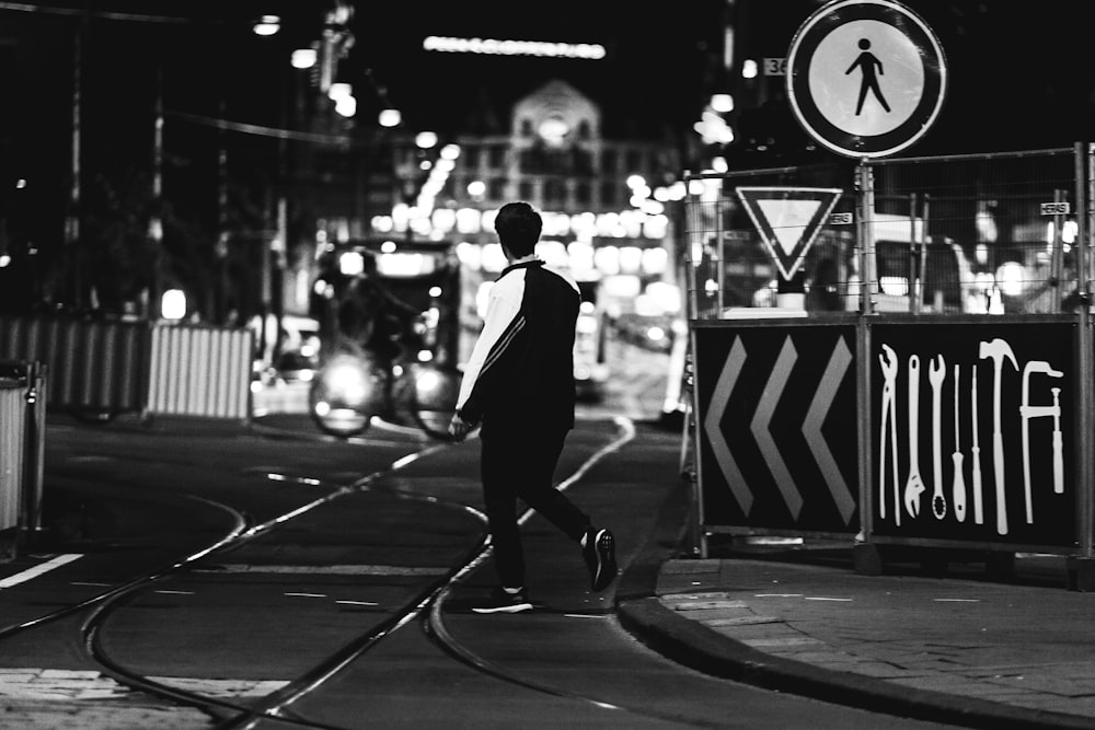 grayscale photography of man near road