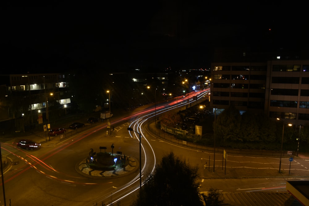 time lapse photography of road near high-rise buildings at night time