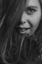 A tasteful close-up of a young woman with a playful smile, hinting at intimacy.