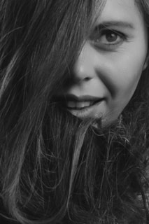 An intimate black-and-white photo capturing a model's playful smile