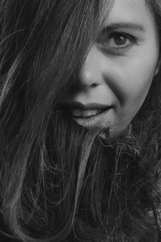 A close-up of a confident woman smiling with a playful glance.