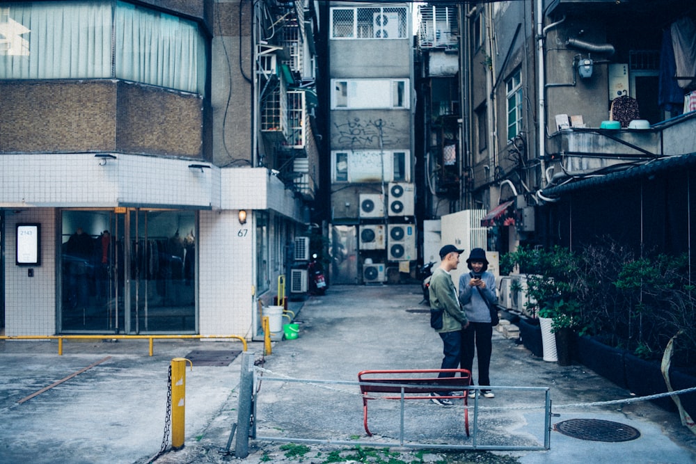 two people standing beside building