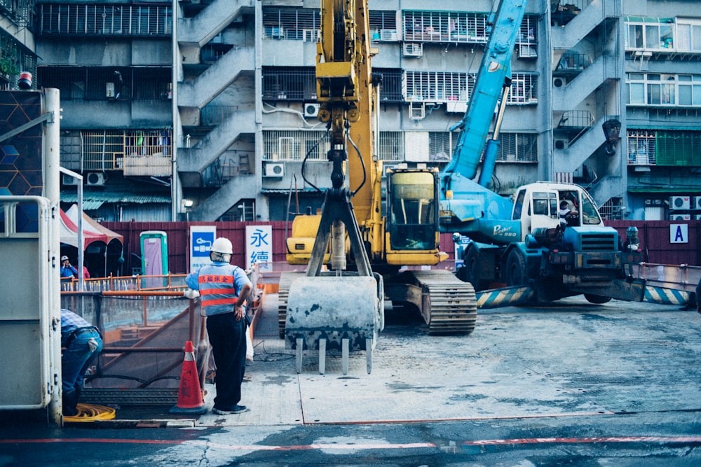 yellow backhoe near man standing