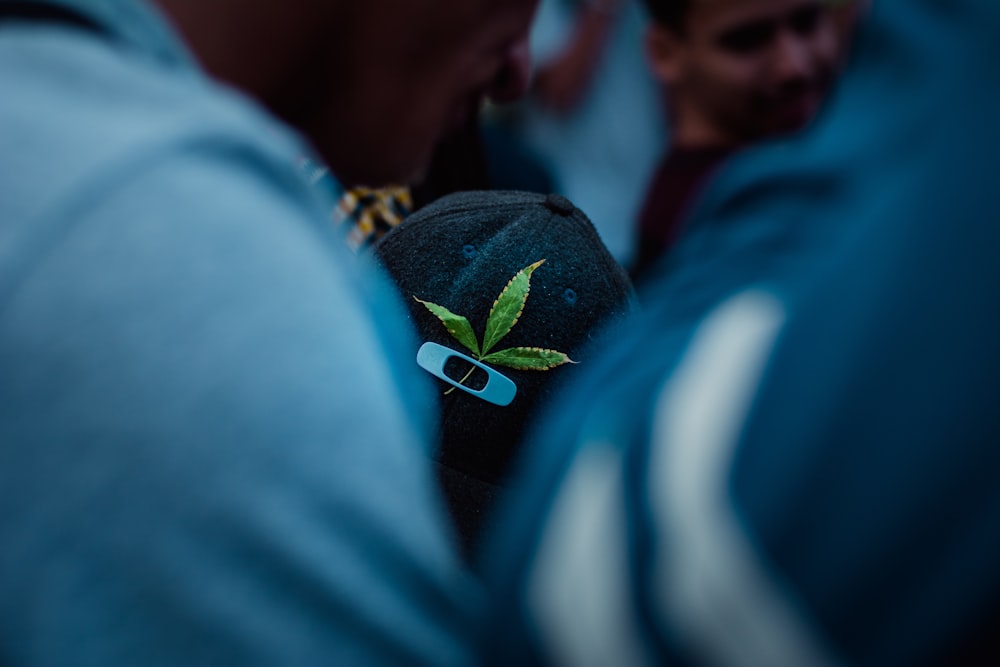 a man wearing a hat with a marijuana leaf on it