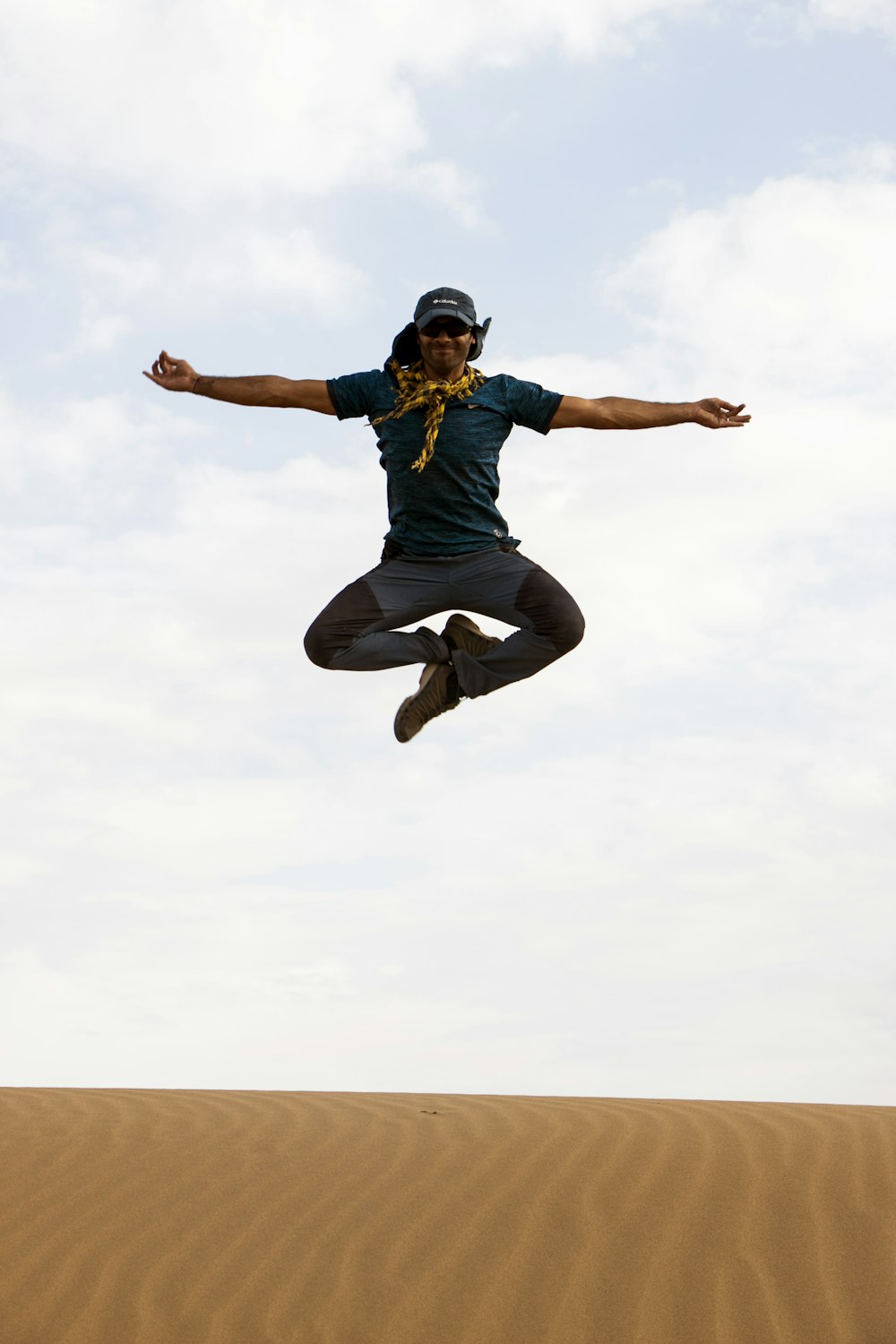 man jumping on sand during daytime