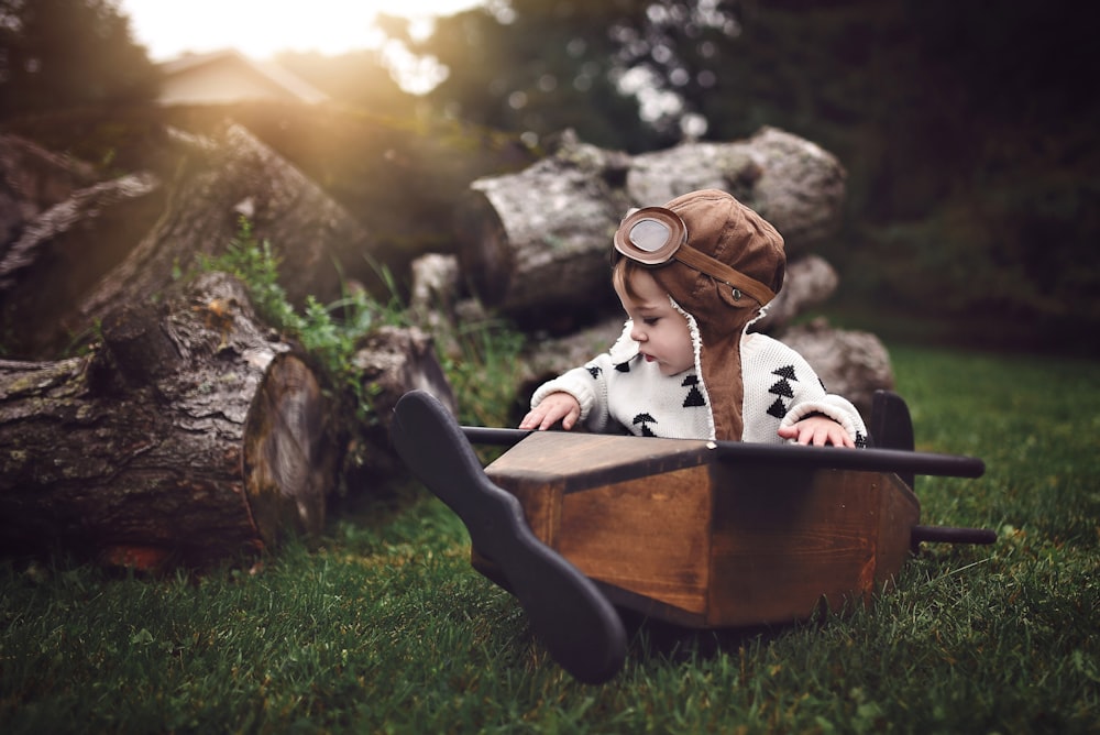 toddler riding monoplane on green grass