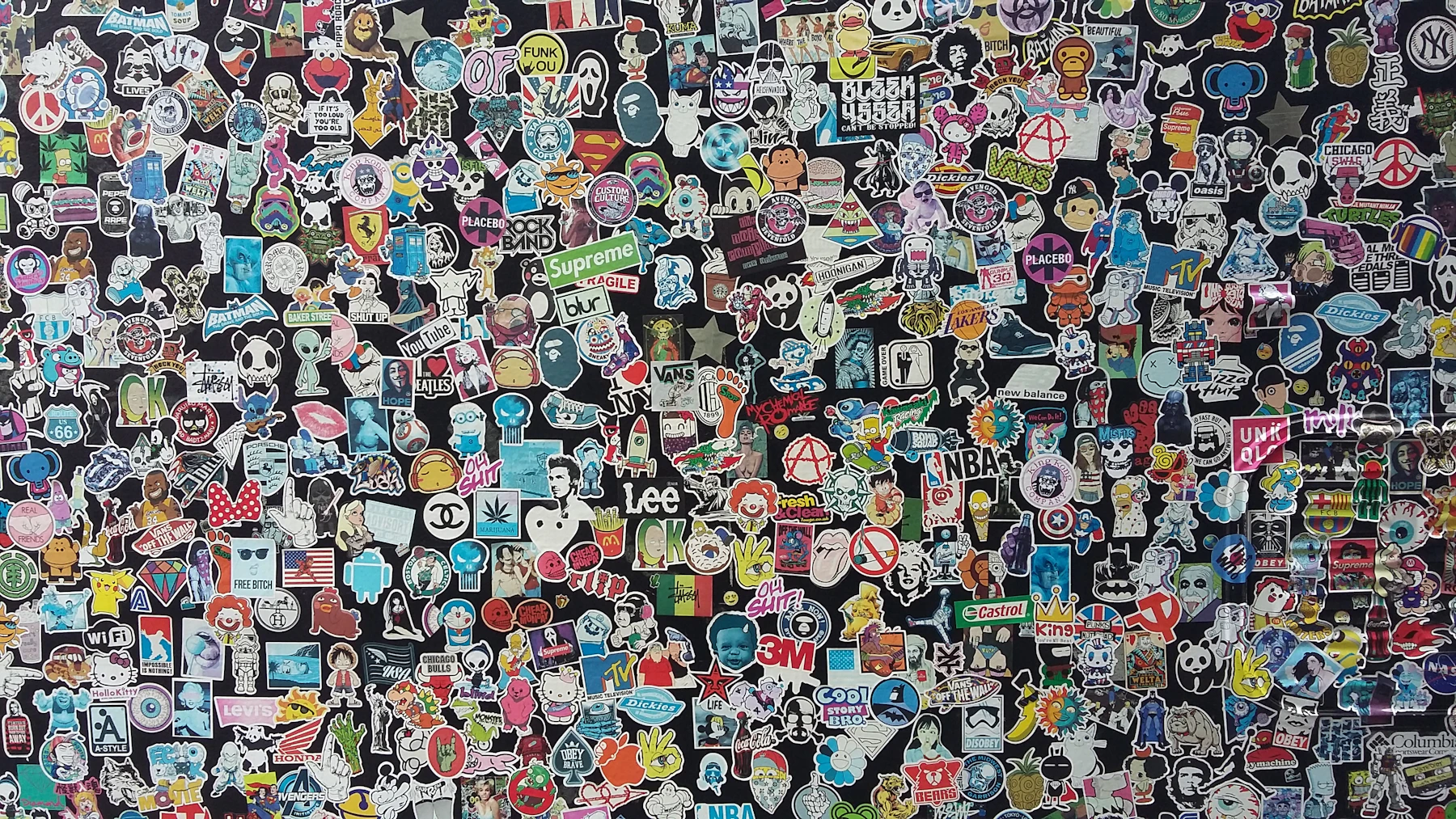 Hundreds of small colorful stickers packed edge to edge across a dark board