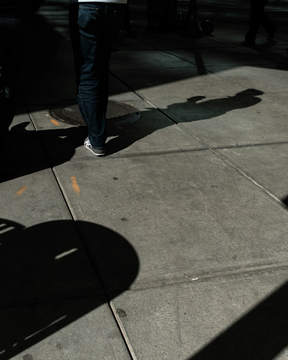 a person standing on a sidewalk with a skateboard