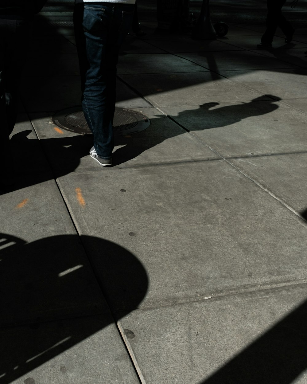 una persona in piedi su un marciapiede con uno skateboard