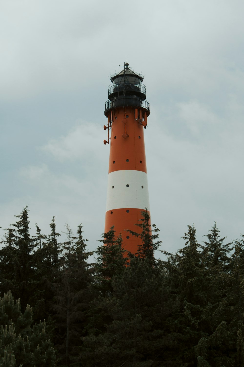 orange and white lighthouse under white sky