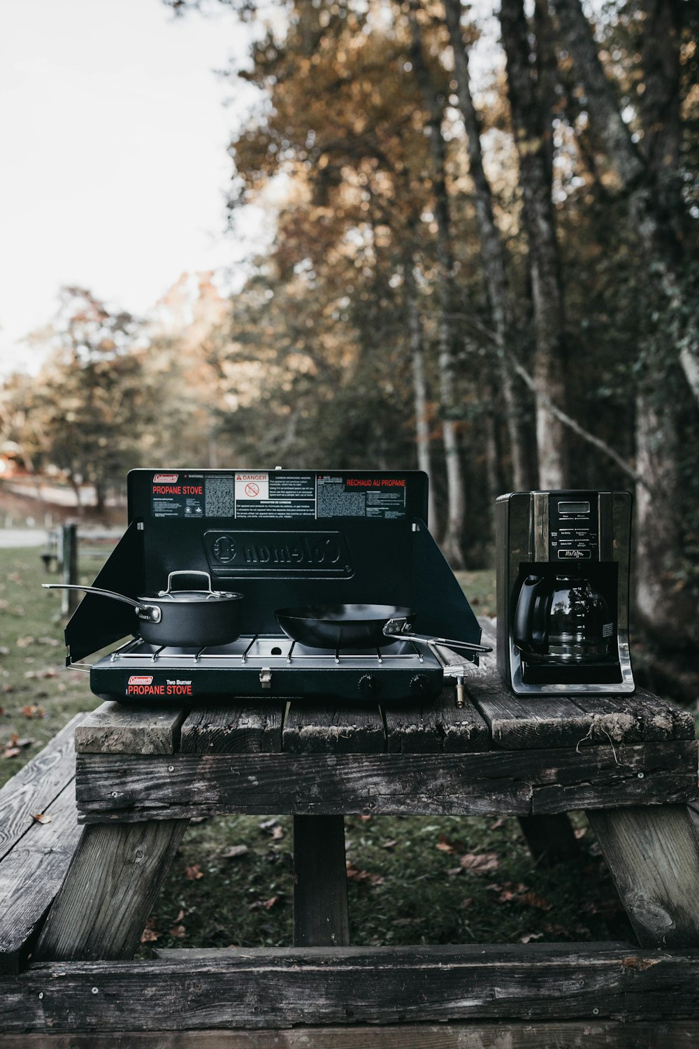 gray electric strove beside black coffeemaker near trees