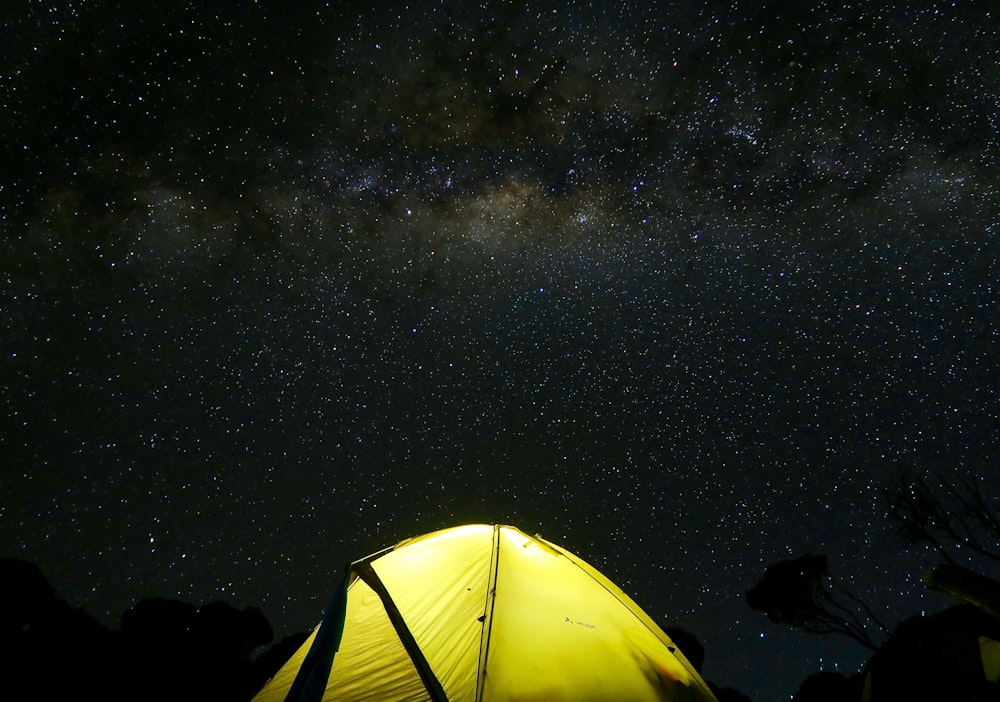 Carpa amarilla bajo el cielo negro durante la noche