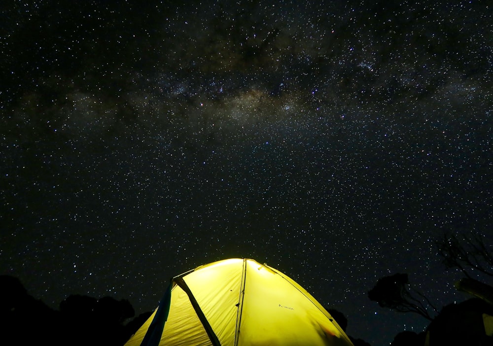 yellow tent under black sky during nighttime