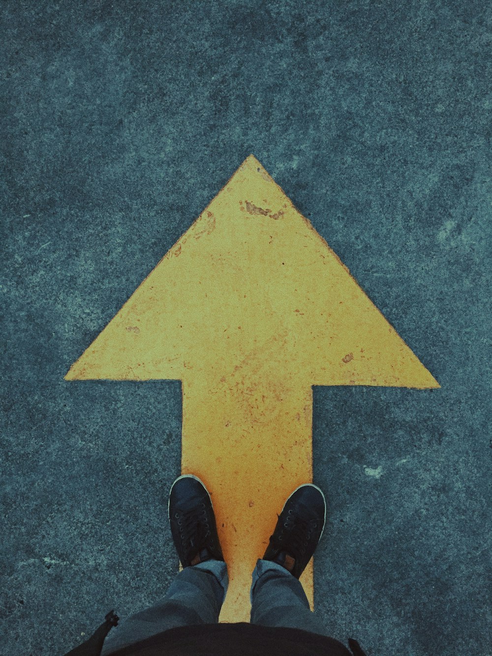 person standing on yellow arrow