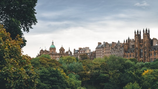 beige castle near trees during daytime in Princes Street Gardens United Kingdom