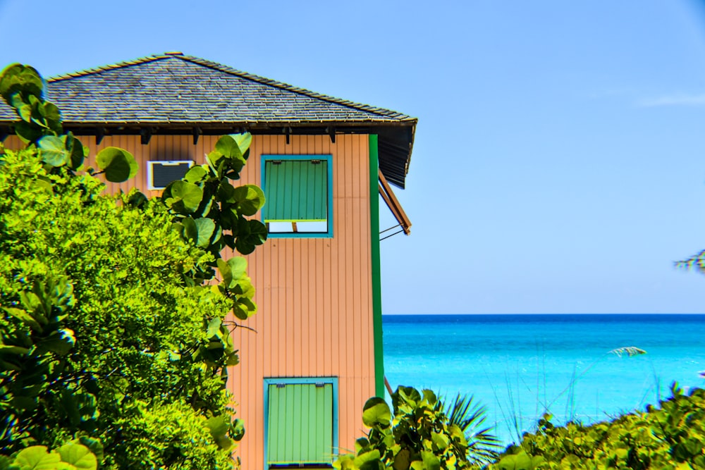 view of pink house near body of water