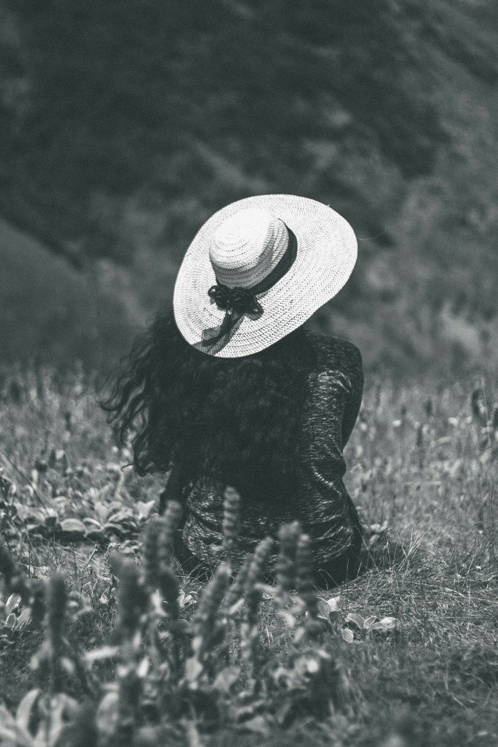 woman sitting on ground wearing sunhat