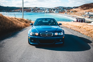 A sleek taxi driving along a scenic coastal road in Greece.