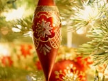 A close-up of a handcrafted red cardinal ornament glowing softly in natural light.