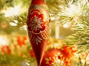 A close-up of a handcrafted red cardinal ornament glowing softly in natural light.