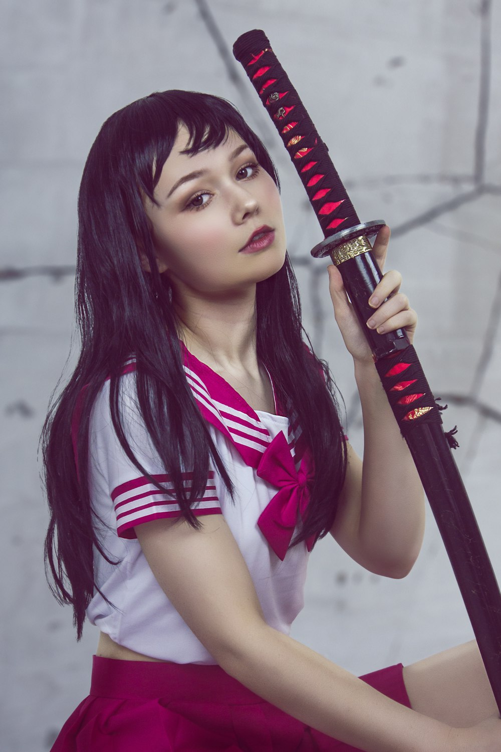 woman in red and white sailor uniform holding katana