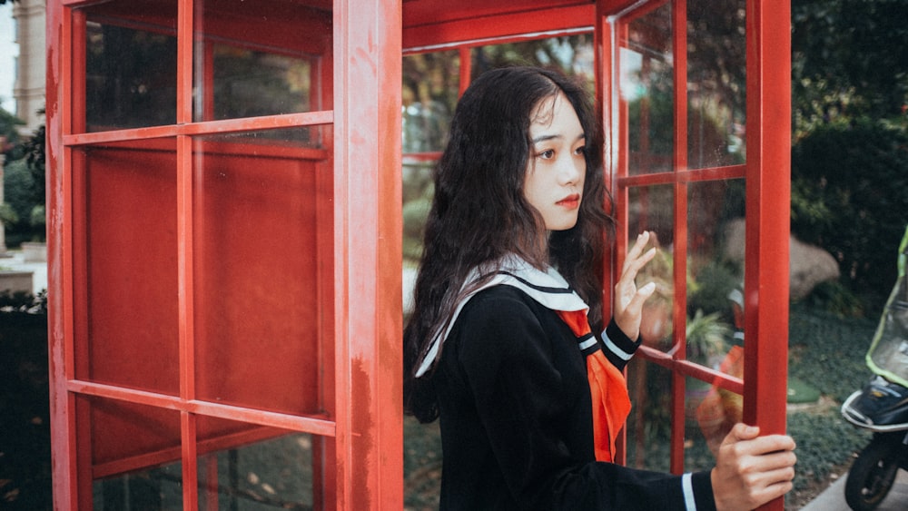 woman standing inside telephone booth