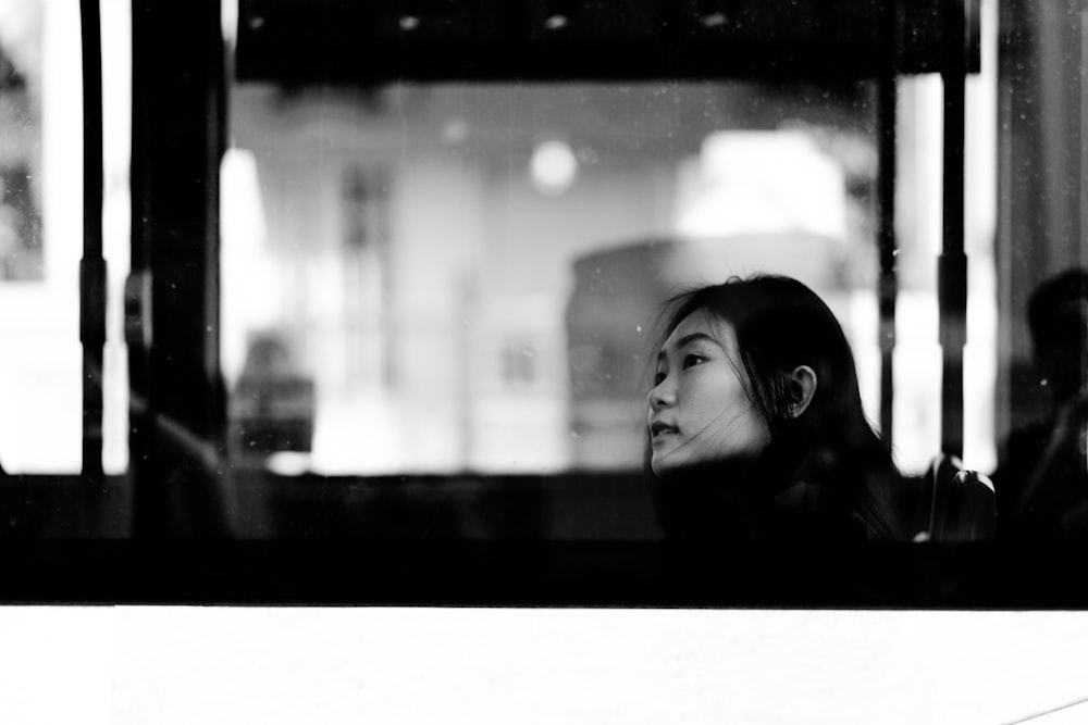 a woman sitting on a bus looking out the window