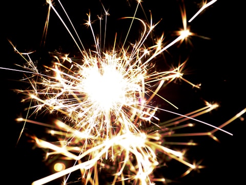 Macro shot of sparks igniting against a pitch-black background.