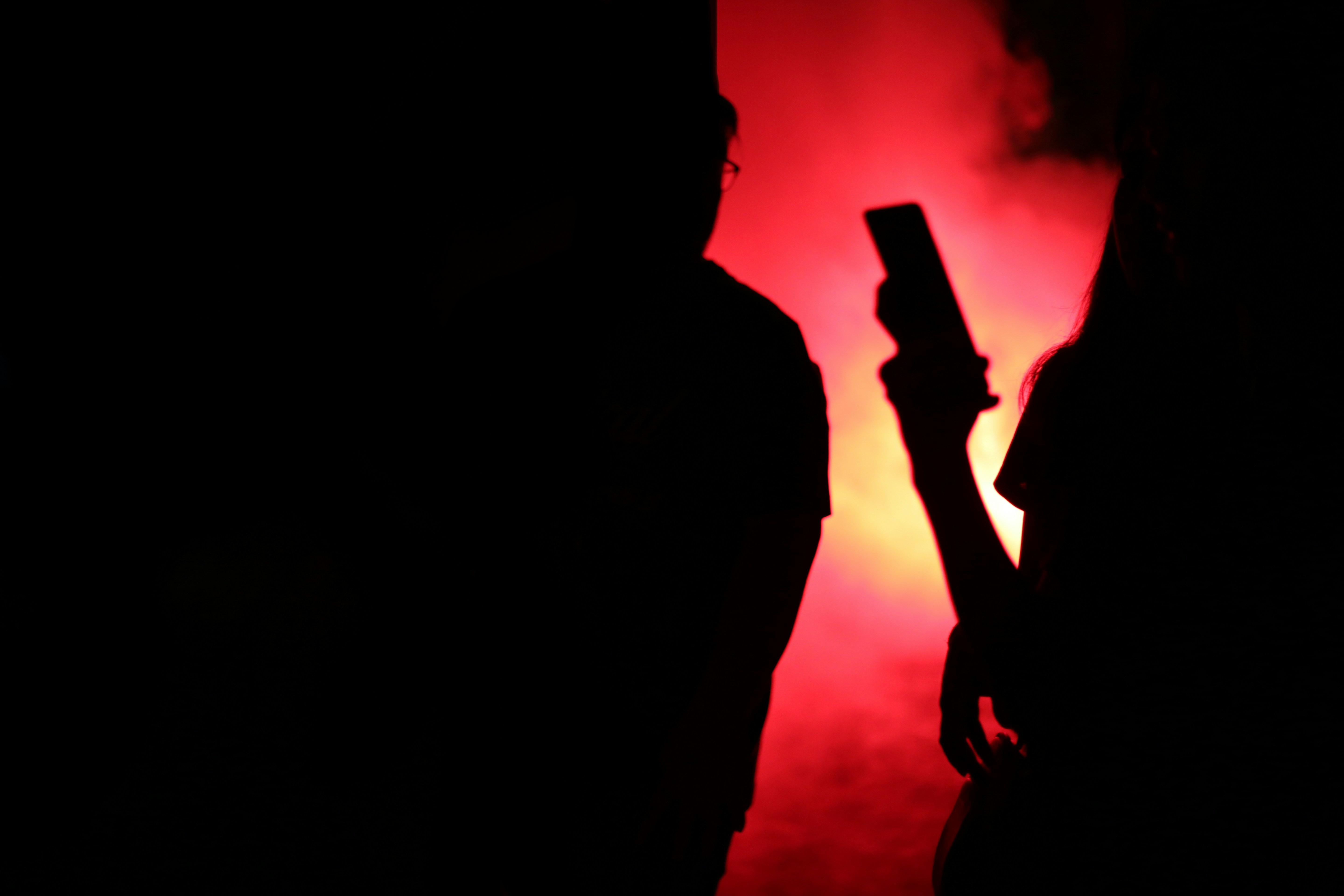 Two silhouettes against a vivid glowing sky, intimate close stance, surrounded by light