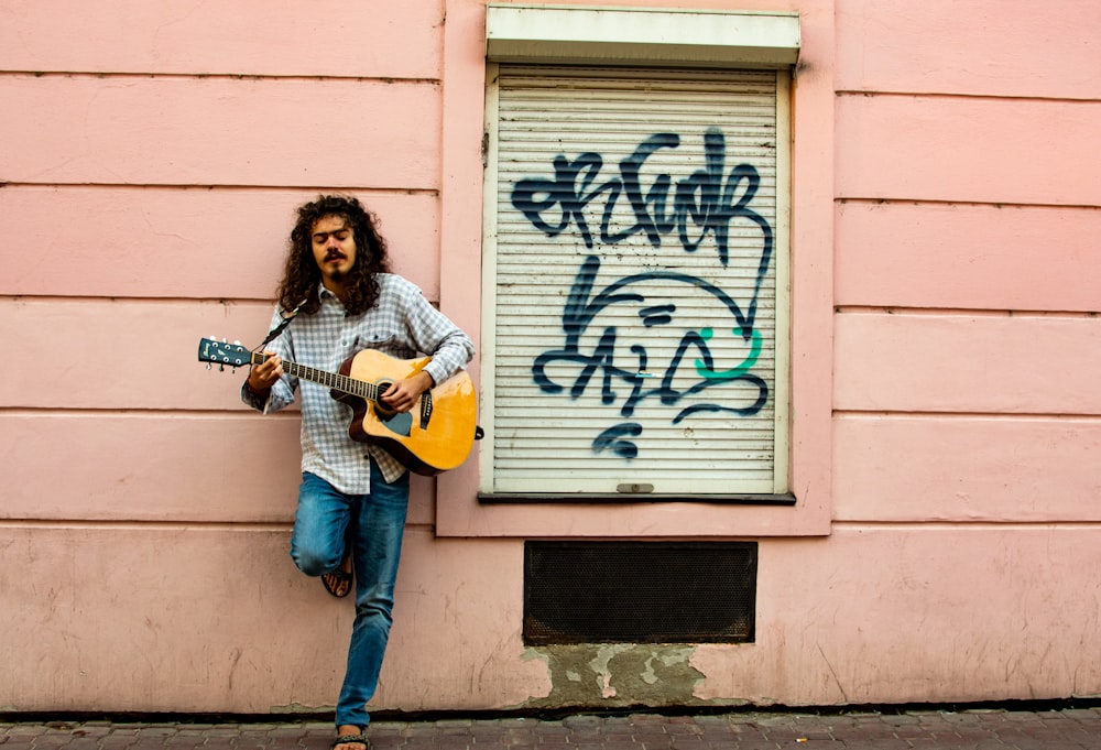 man playing guitar on street during daytime